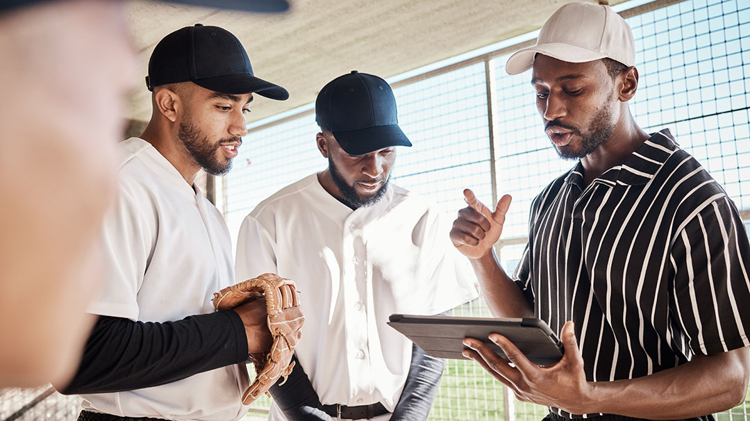 A student-athlete discussing recruitment opportunities with a college baseball coach.